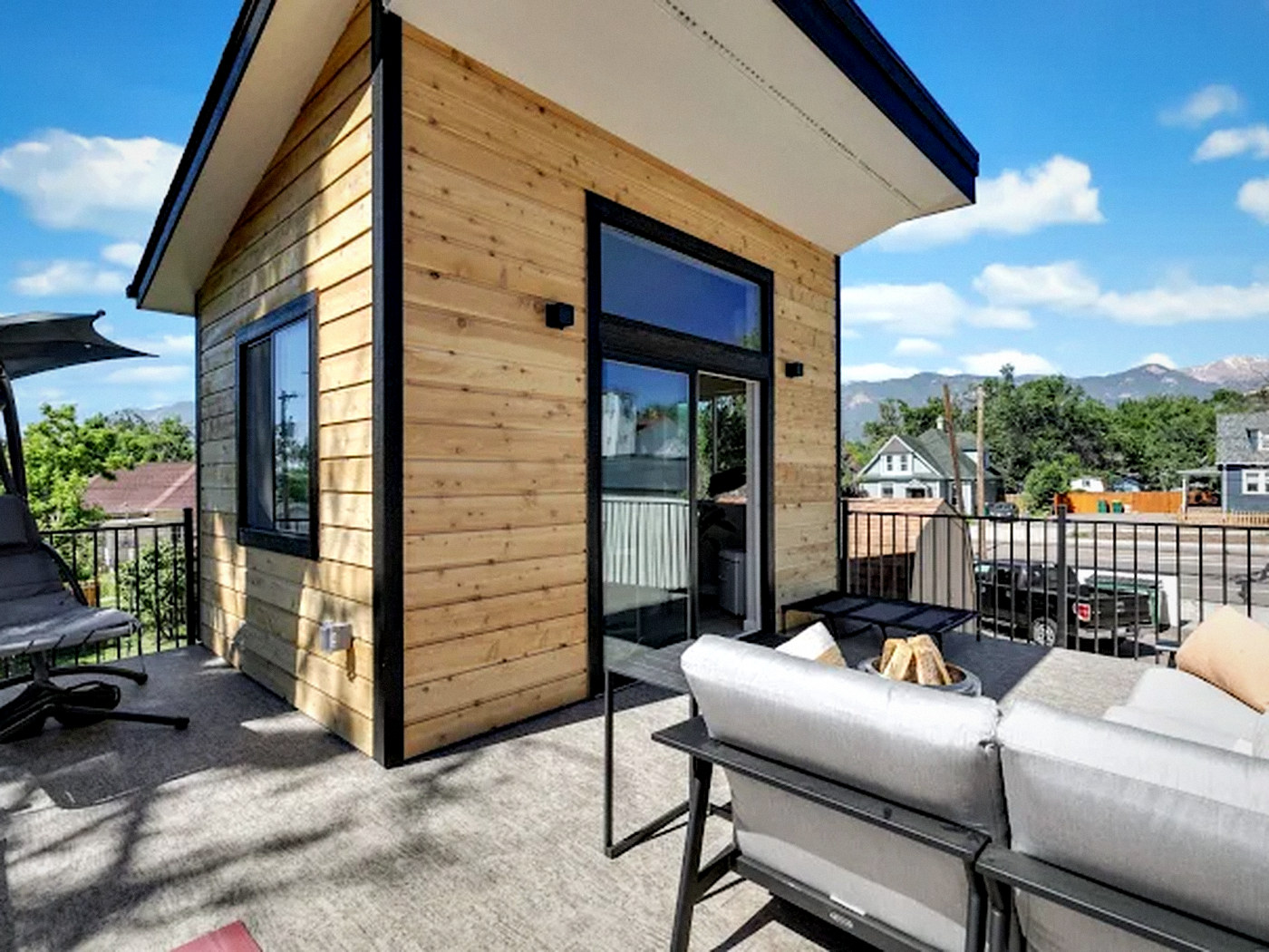Modern detached ADU with horizontal cedar siding, black trim and a sliding glass door in Arvada, CO